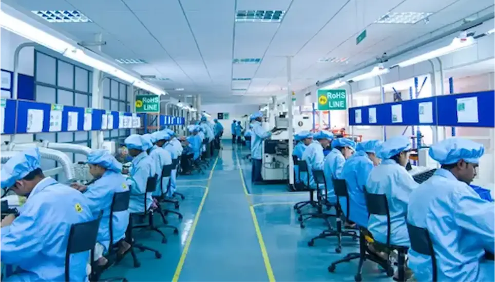 Technicians assembling PCBs on RoHS-compliant electronics manufacturing line in cleanroom facility